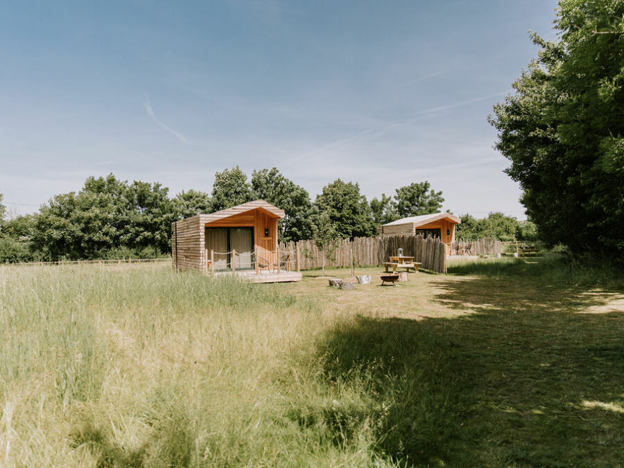 Luxury glamping cabins surrounded by meadows grasses and wildflowers in rural Bedfordshire