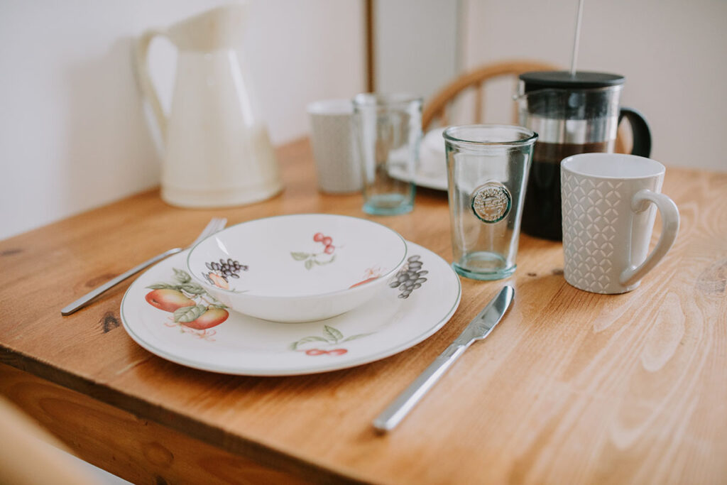 Crockery and cutlery laid on table