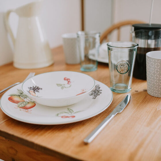 Crockery and cutlery laid on table