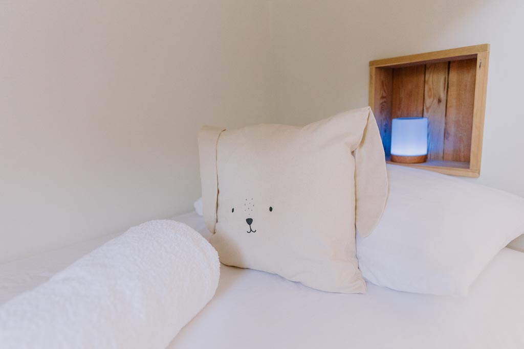 Glamping with kids - Cabin bunk bed with animal cushion and night time reading lamp