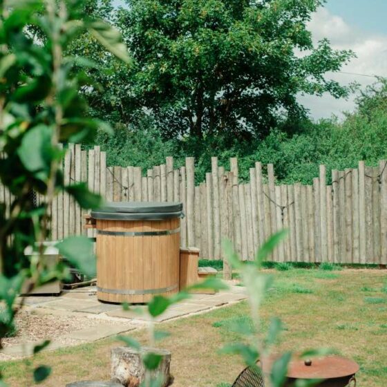 A cosy wood-fired hot tub at the meadows at polehanger luxury glamping site, nestled among the trees